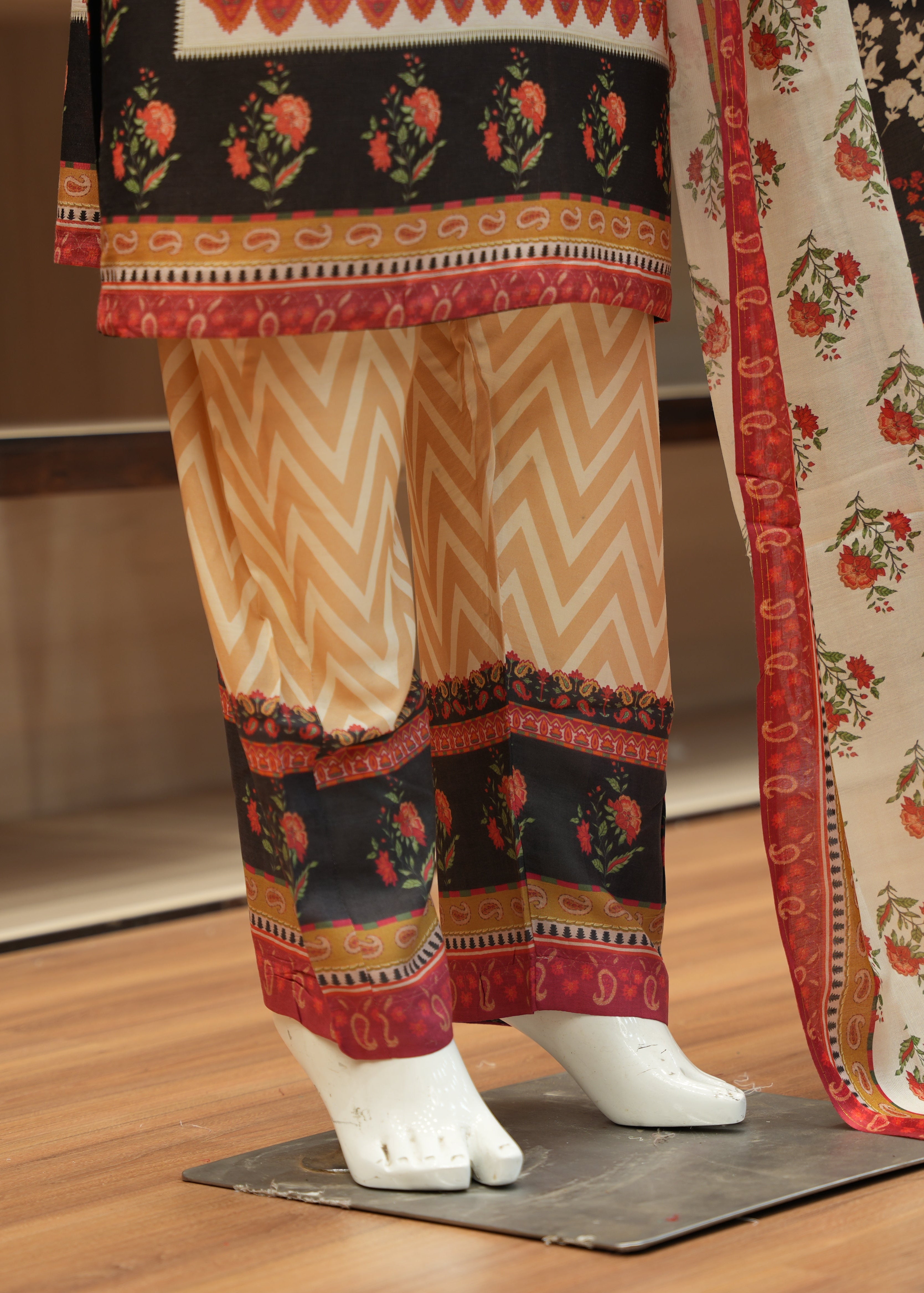 Traditional outfit with a floral patterned dupatta on a wooden floor.