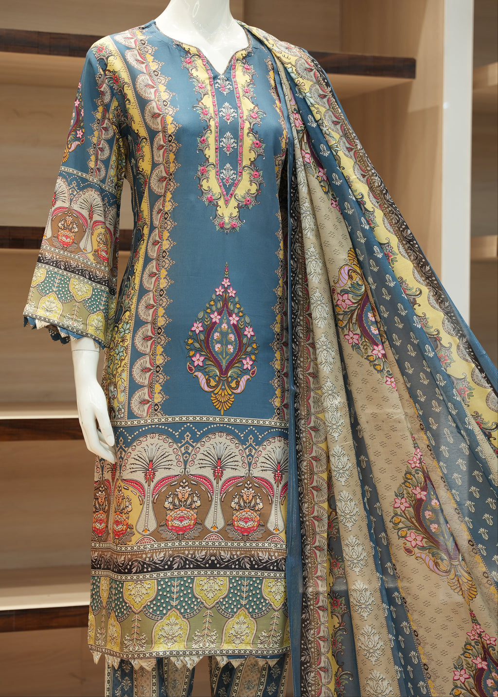 Colorful embroidered traditional outfit on a mannequin with a wooden shelf background