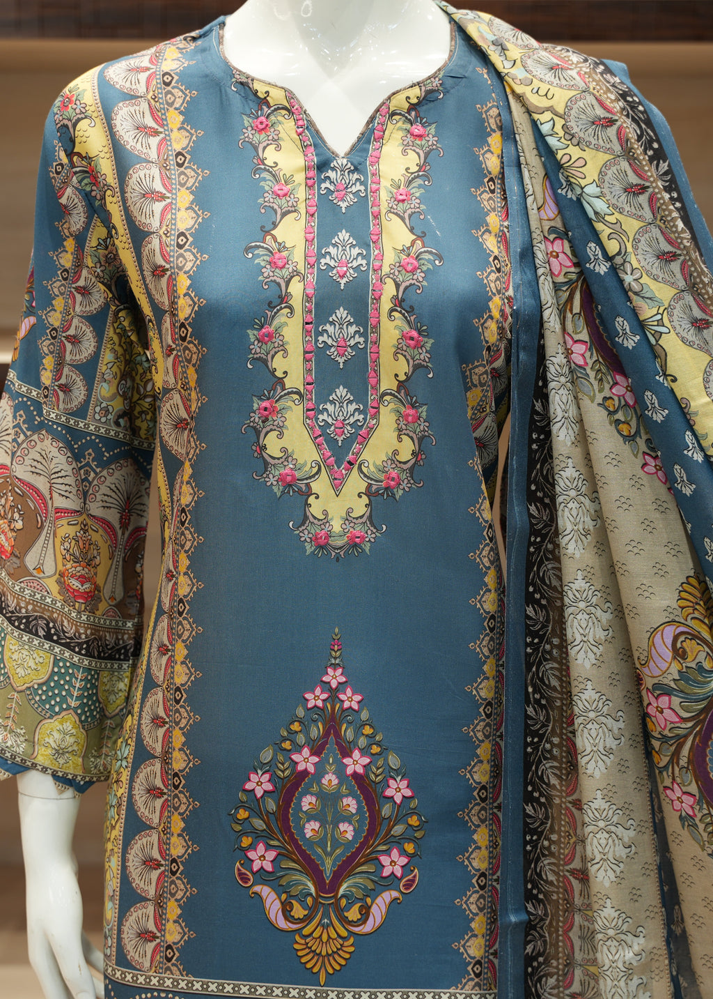 Decorative traditional garment with intricate patterns on a mannequin.