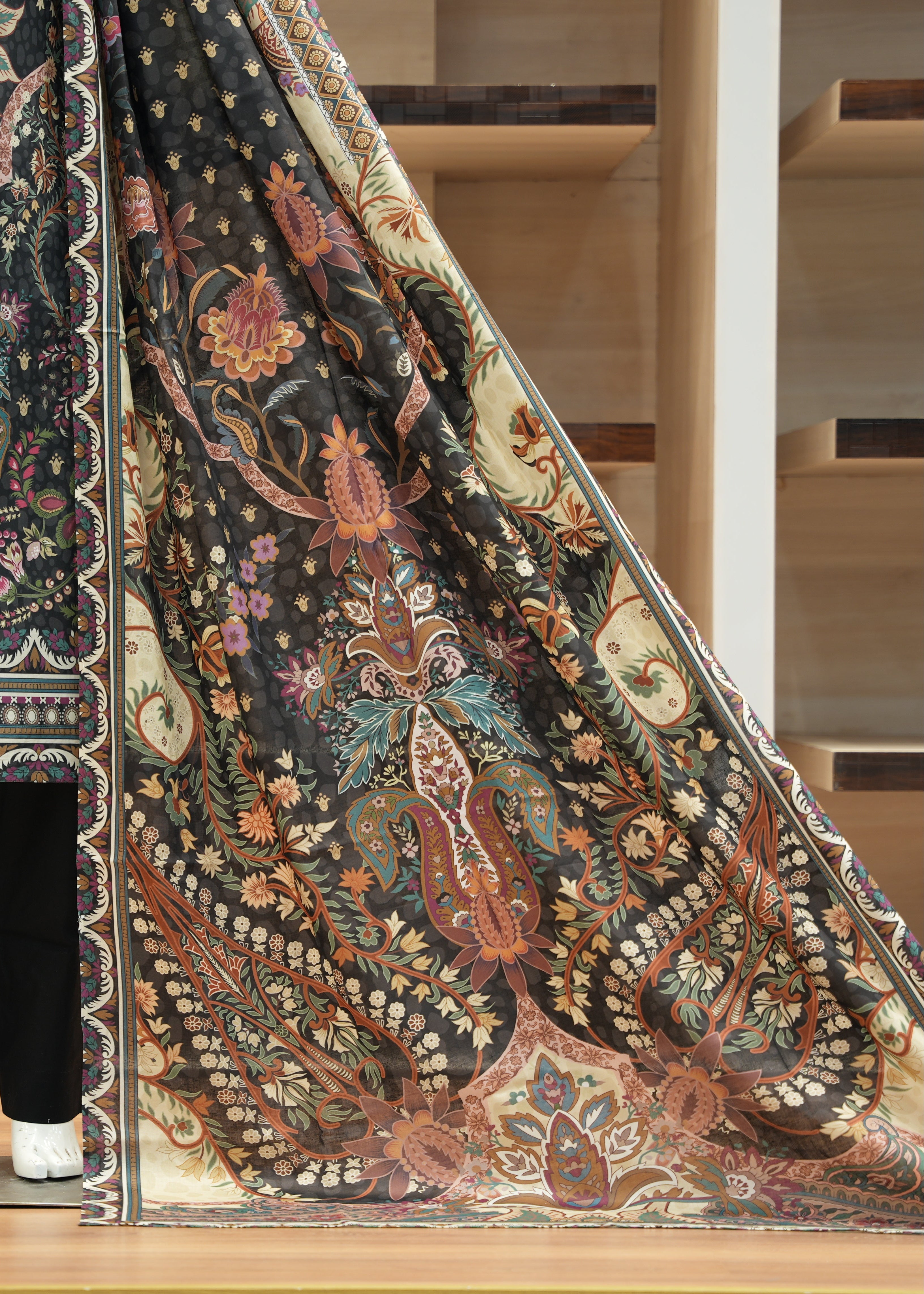 Mannequin wearing a patterned outfit with a large fabric swatch displaying intricate designs.