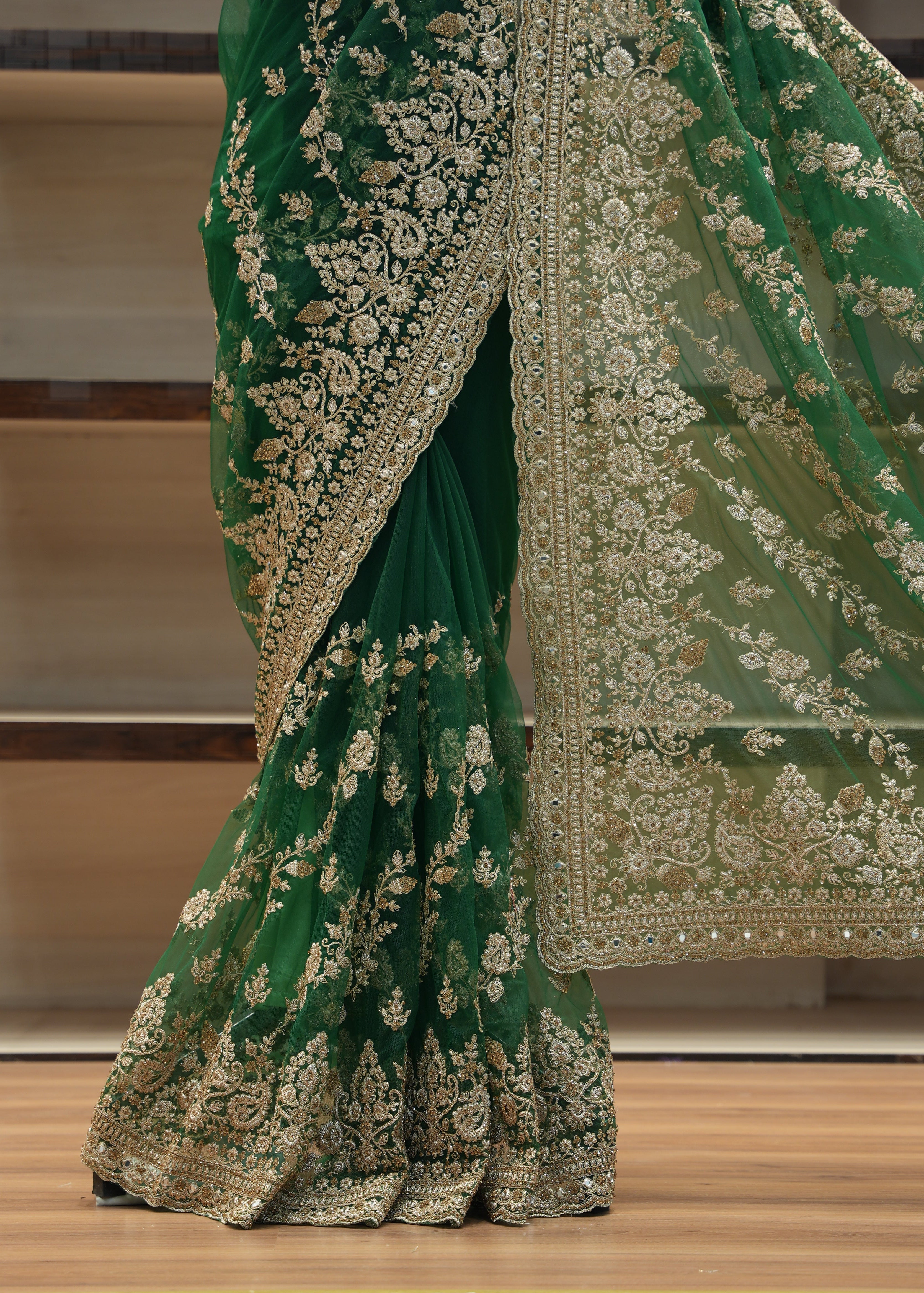 Green embroidered fabric draped over a chair with a blurred background