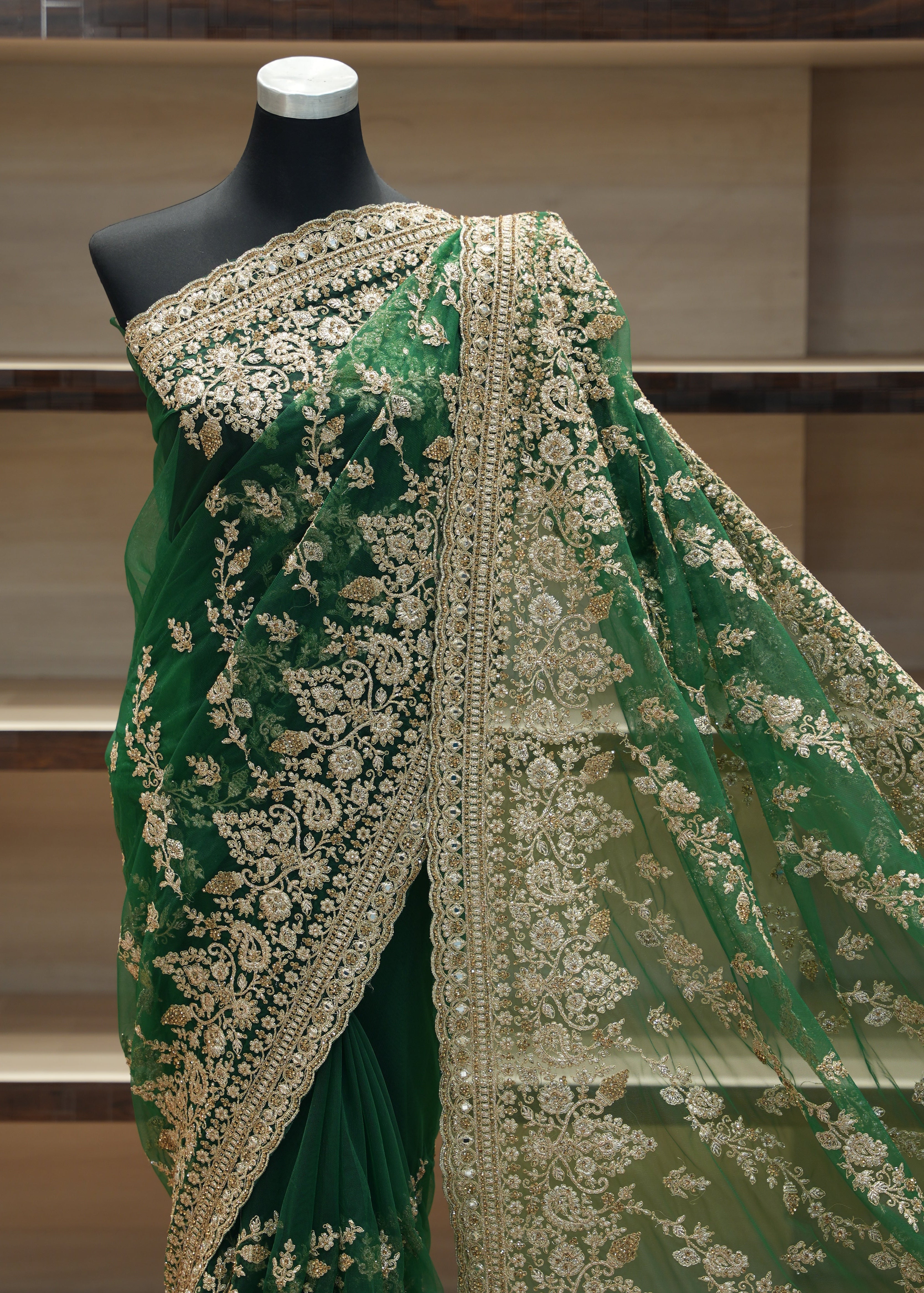 Green embroidered fabric on a mannequin against a neutral background