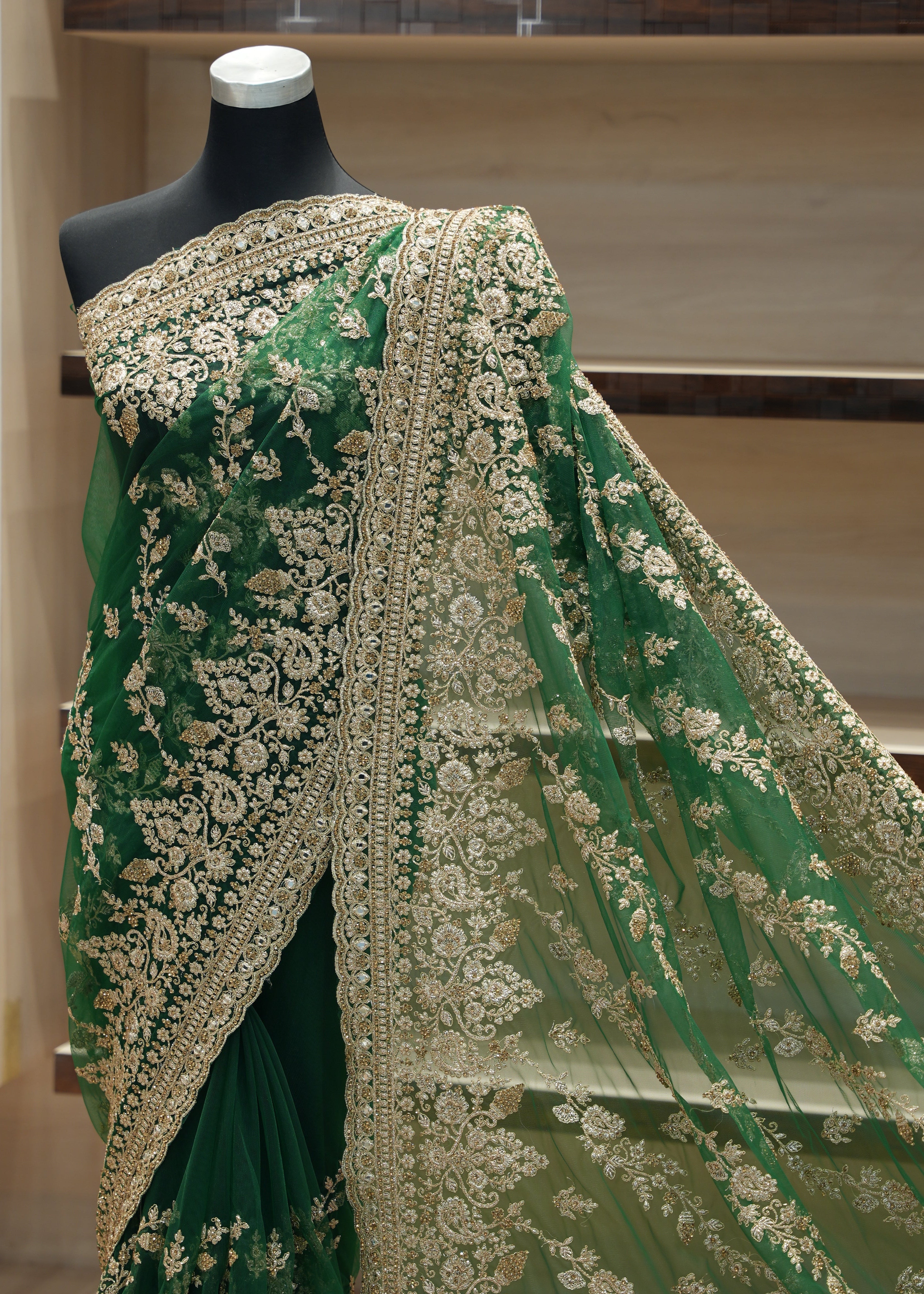 Green embroidered fabric on a mannequin against a neutral background