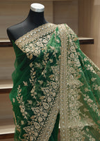Green embroidered fabric on a mannequin against a neutral background