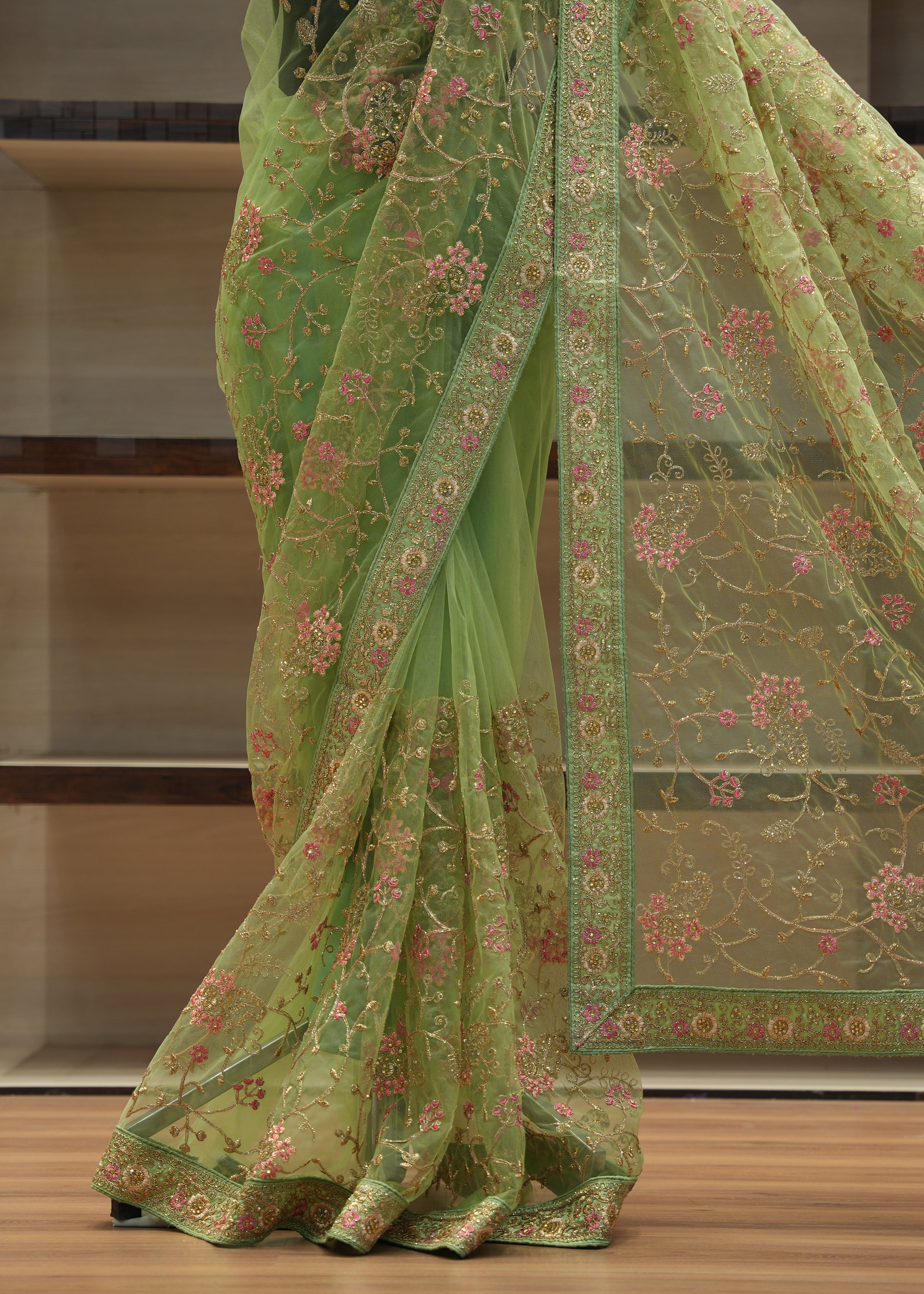 Green embroidered saree with a blurred background