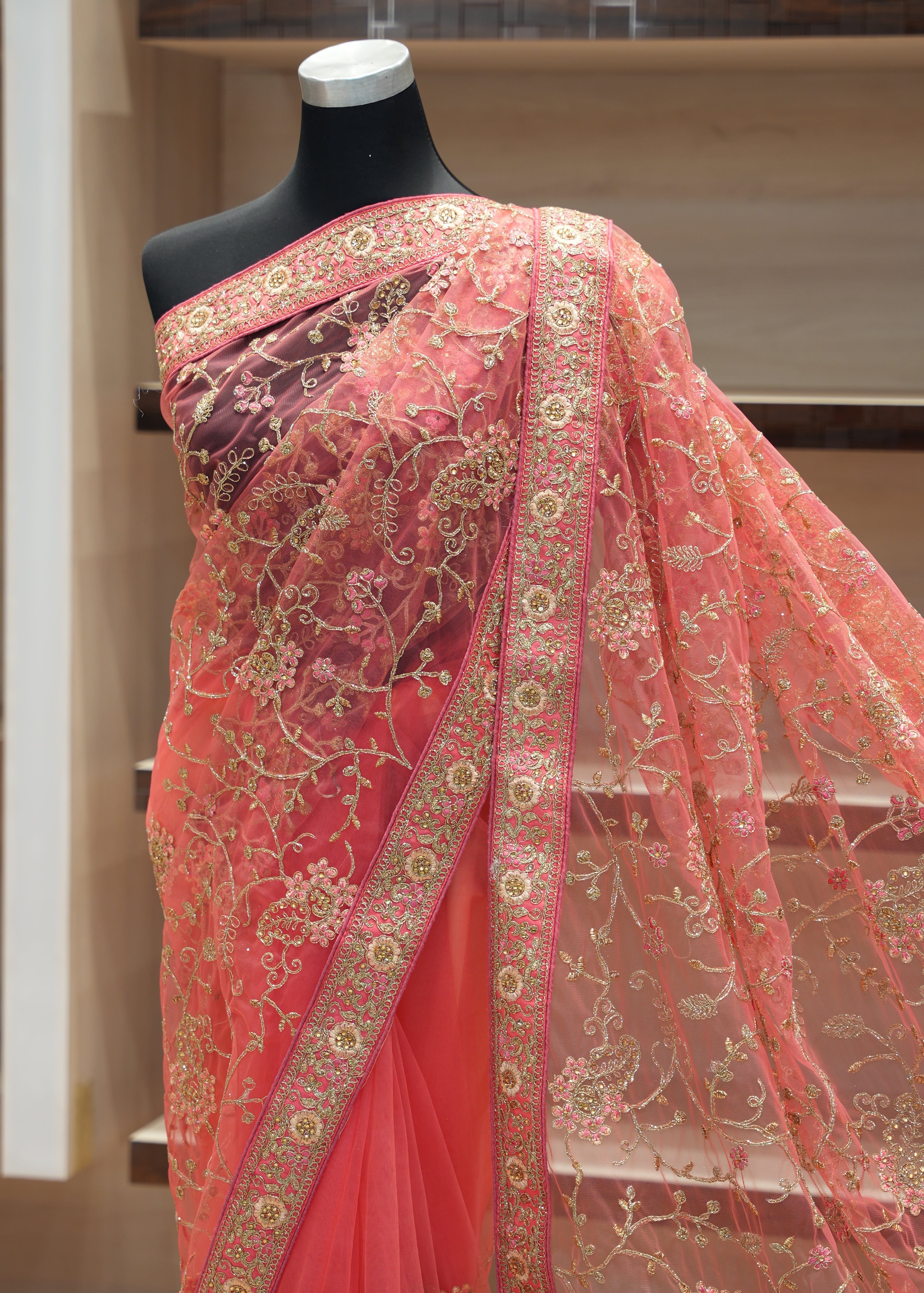 Pink embroidered fabric on a mannequin against a neutral background