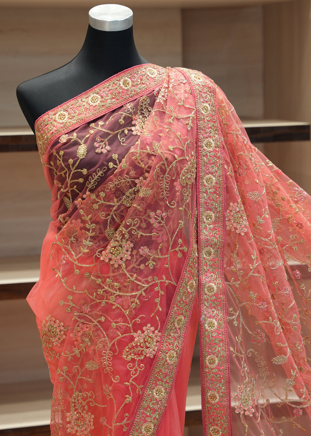 Pink embroidered fabric on a mannequin against a neutral background