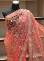 Pink embroidered fabric on a mannequin against a neutral background