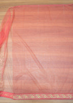 Saree with a red and gold border on a wooden surface