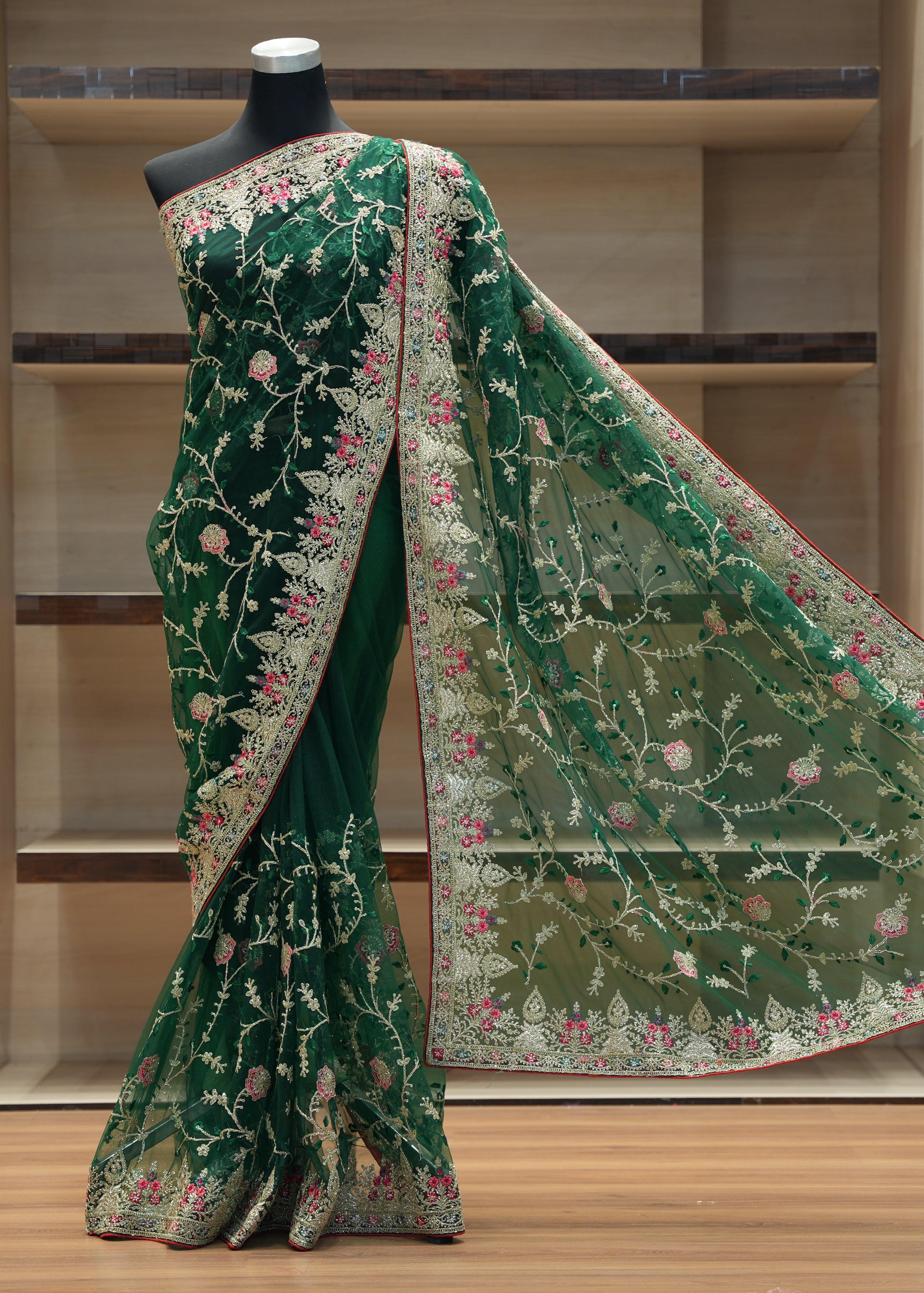Green embroidered saree with matching blouse on a mannequin against a neutral background