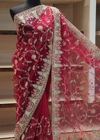 Red saree with intricate white embroidery on a mannequin against a neutral background