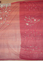 Red fabric with floral embroidery on a wooden surface