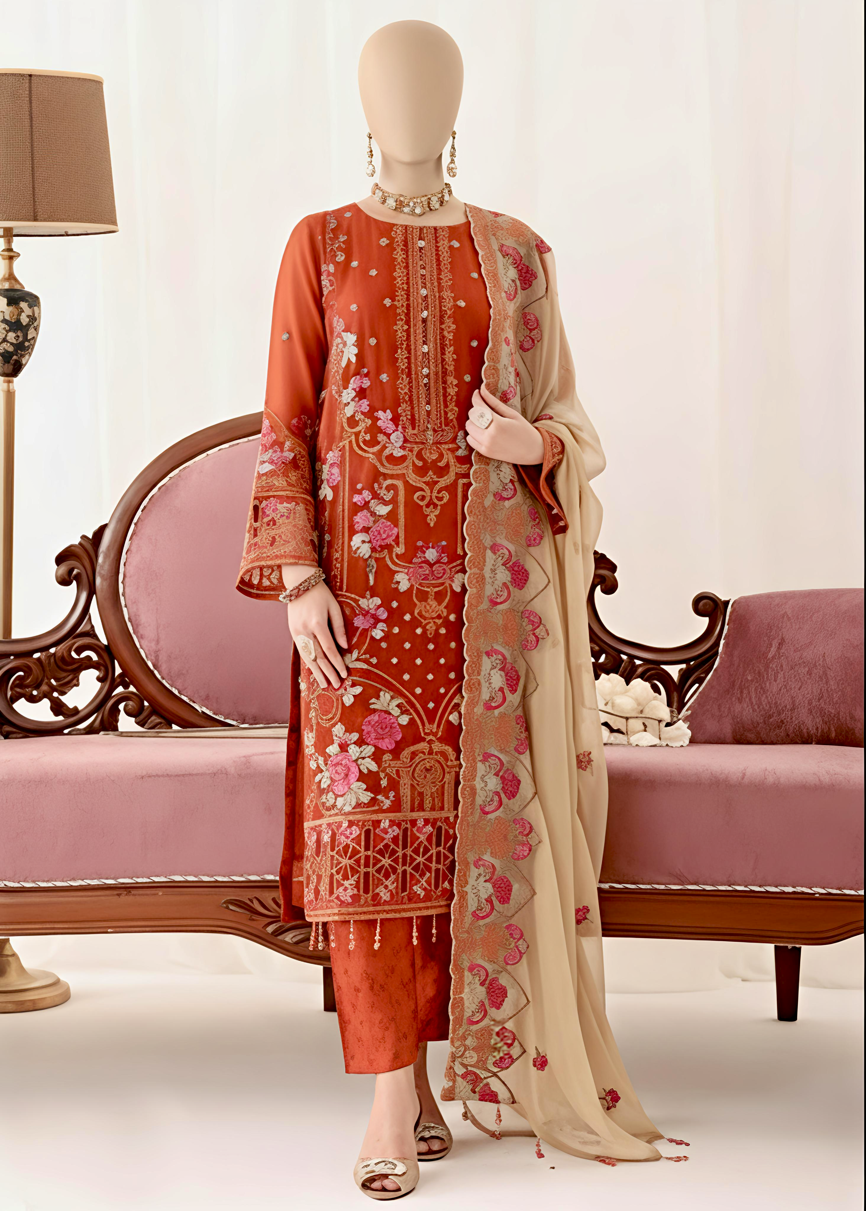 Mannequin wearing an orange embroidered outfit with a matching dupatta on a decorative chair.