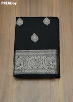 Black saree with white embroidery on a wooden surface, PREMJoy brand visible