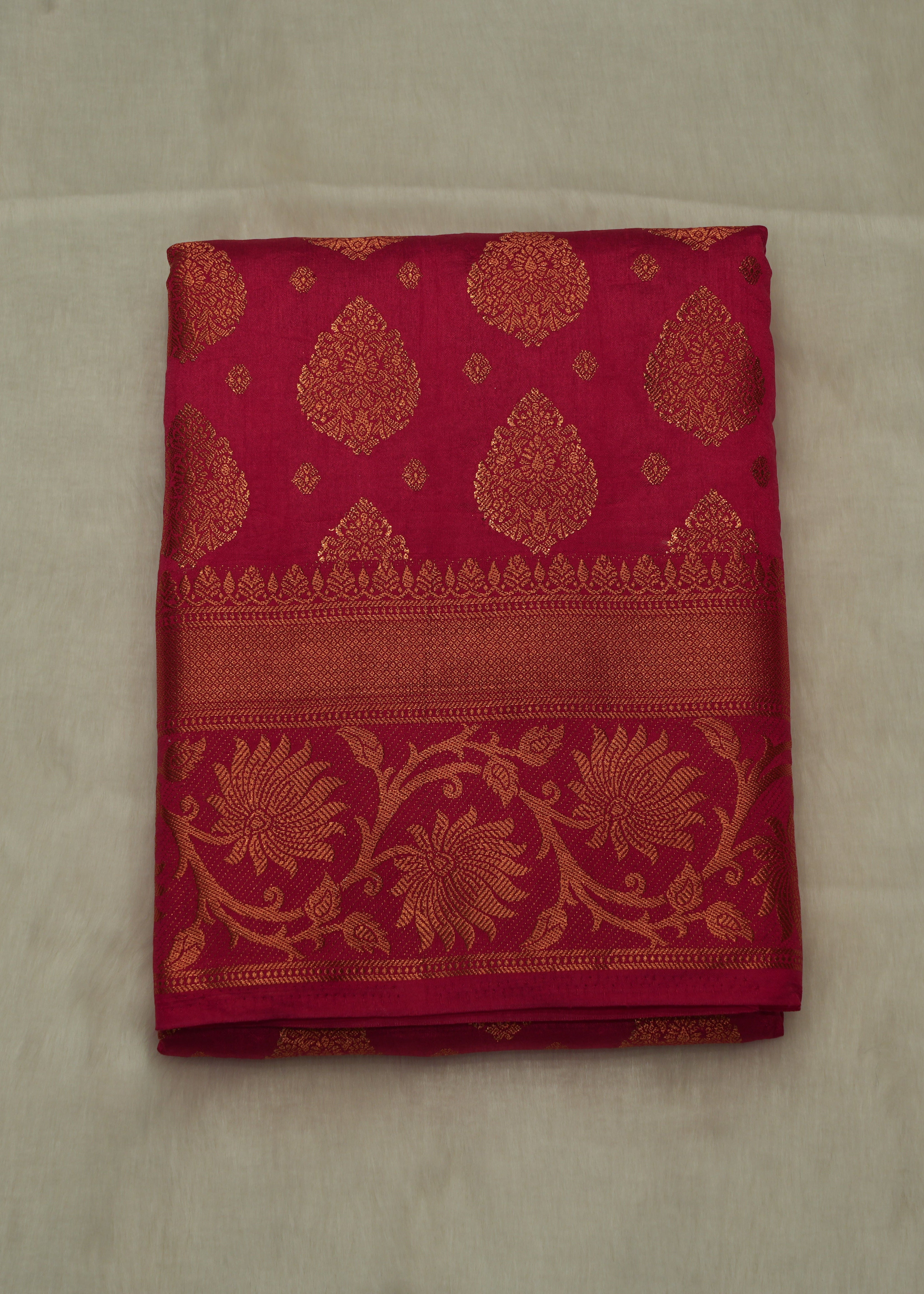 Red fabric with gold floral patterns on a beige background
