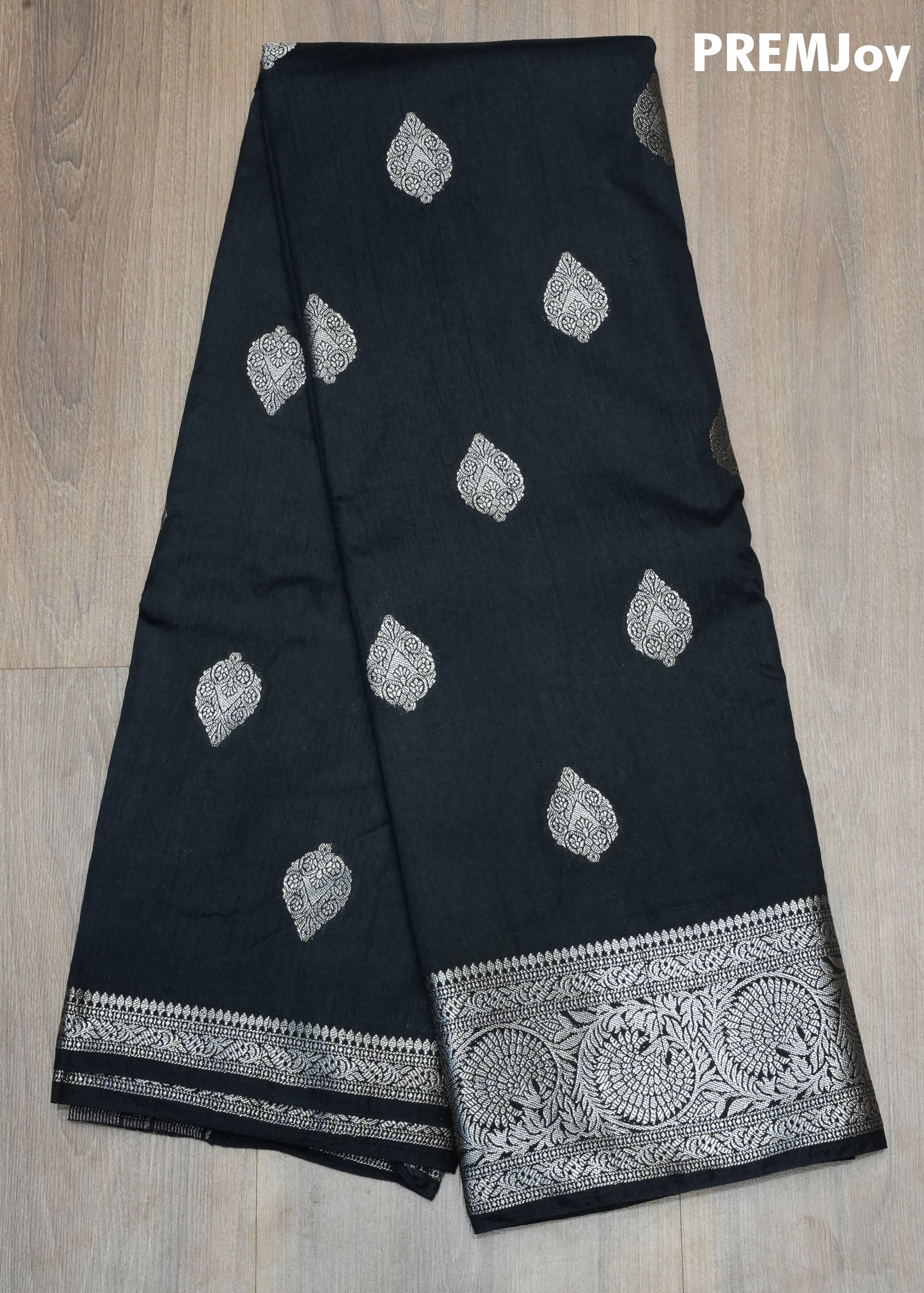 Black fabric with silver leaf patterns and a decorative border on a wooden surface, branded 'PREMJoy'.