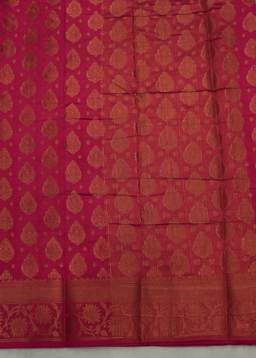 Red fabric with gold patterns on a light gray background