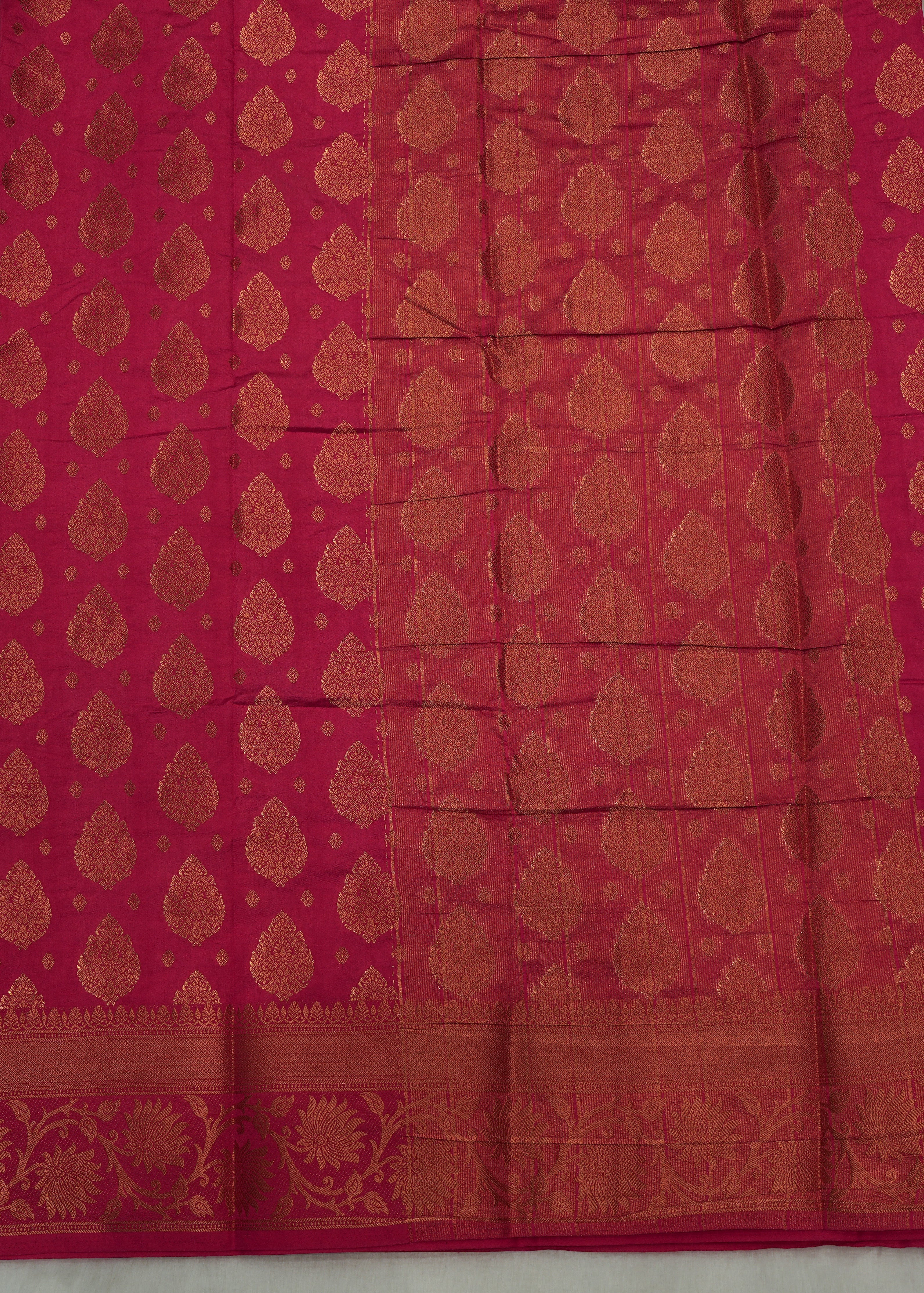 Red fabric with gold patterns on a light gray background