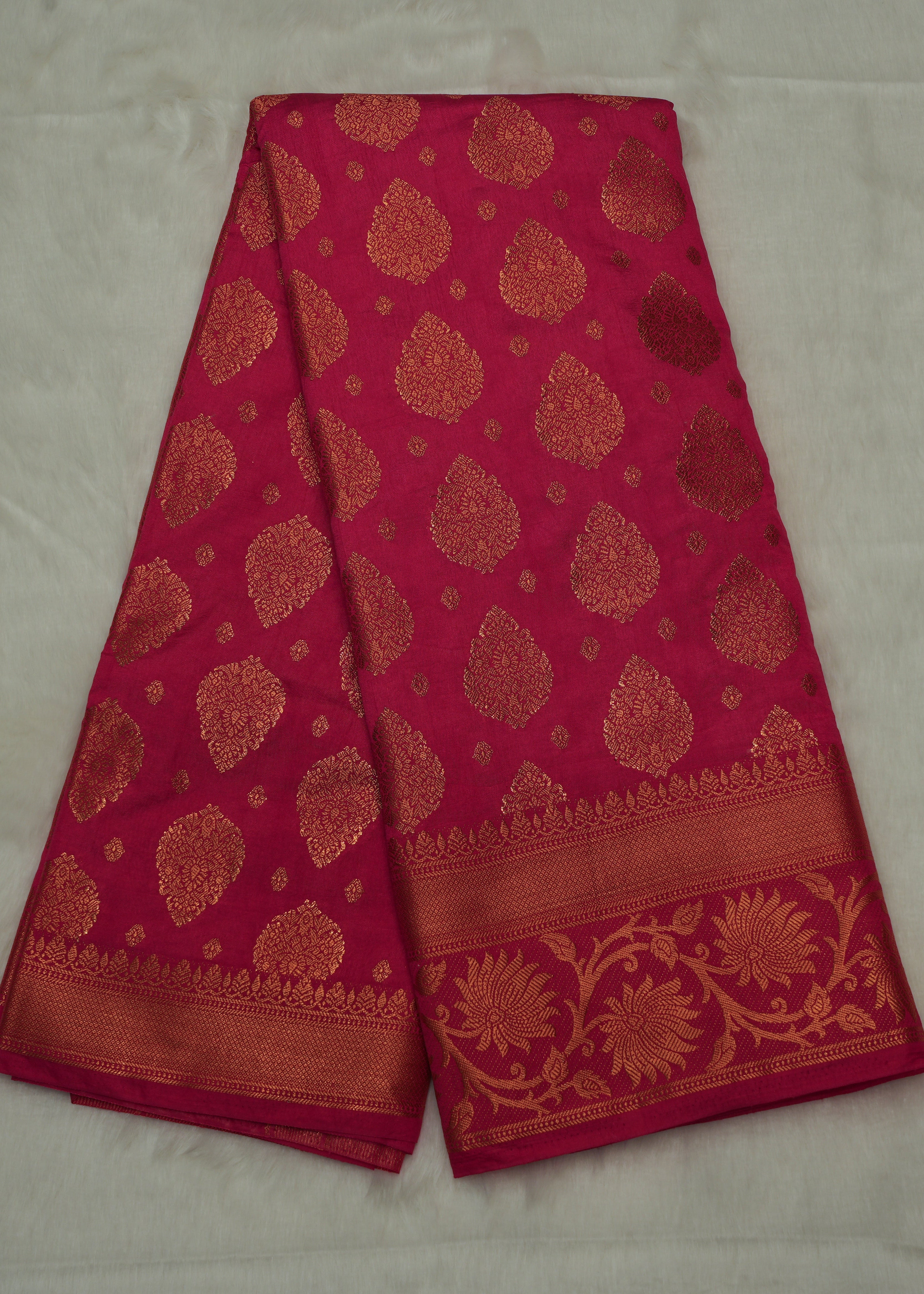 Red fabric with gold patterns on a light gray background