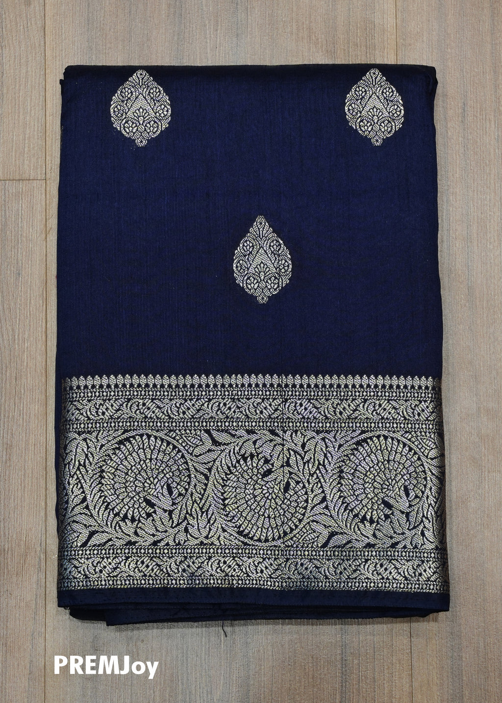 Navy blue fabric with silver embroidery on a wooden surface, branded 'PREMJoy'.
