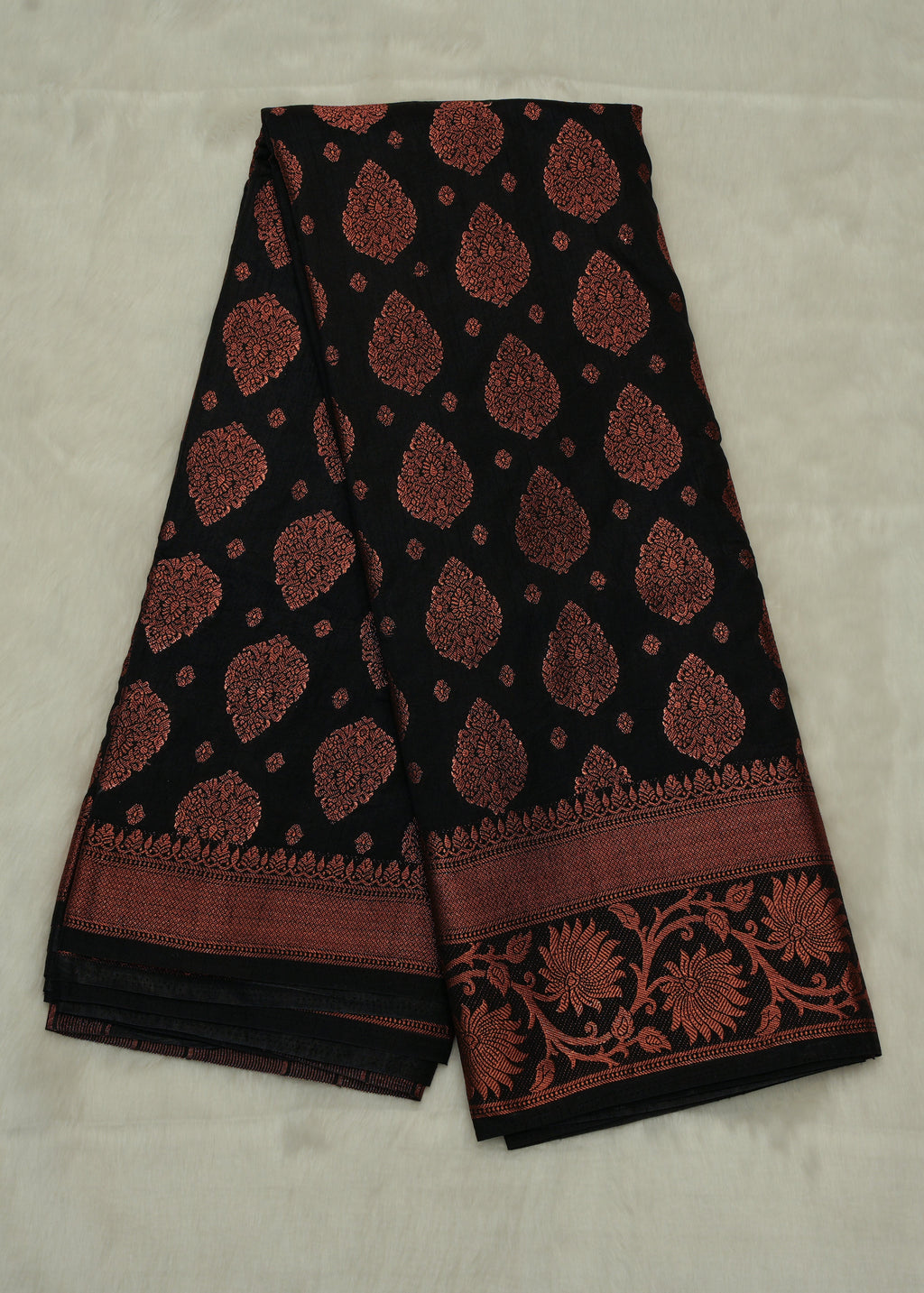 Black saree with red floral patterns on a light gray background