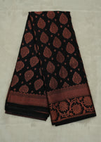Black saree with red floral patterns on a light gray background