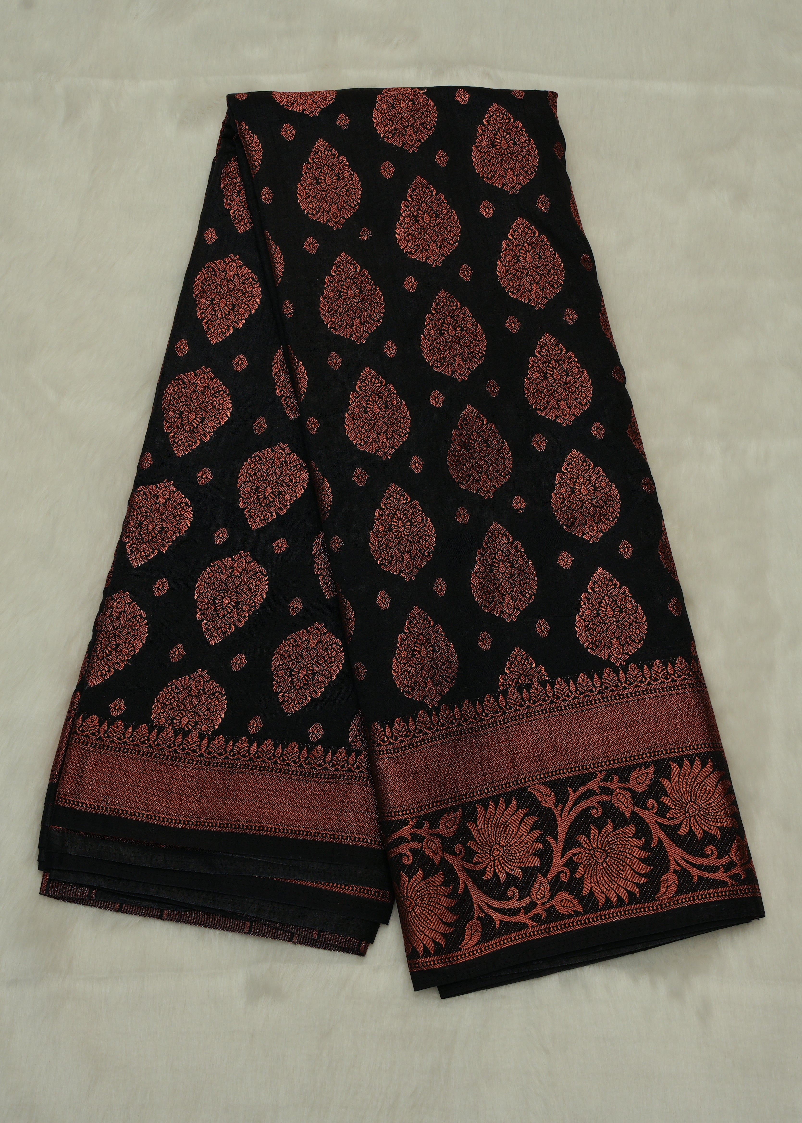 Black saree with red floral patterns on a light gray background