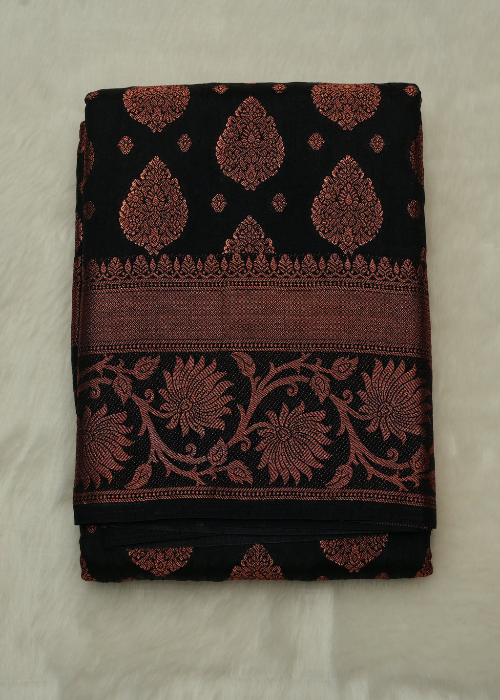Black fabric with red floral patterns on a beige background