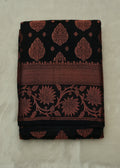 Black fabric with red floral patterns on a beige background