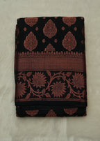 Black fabric with red floral patterns on a beige background