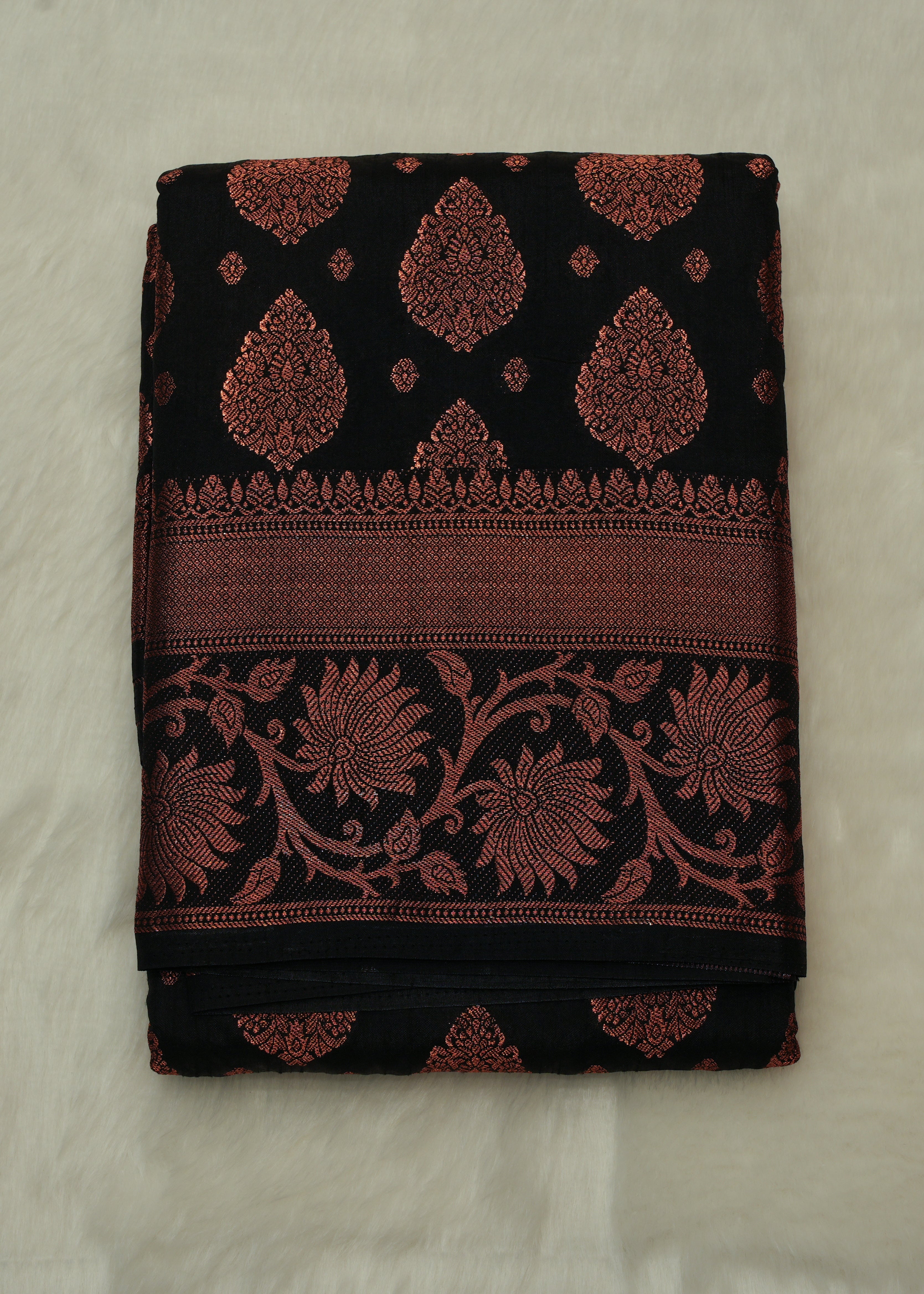 Black fabric with red floral patterns on a beige background