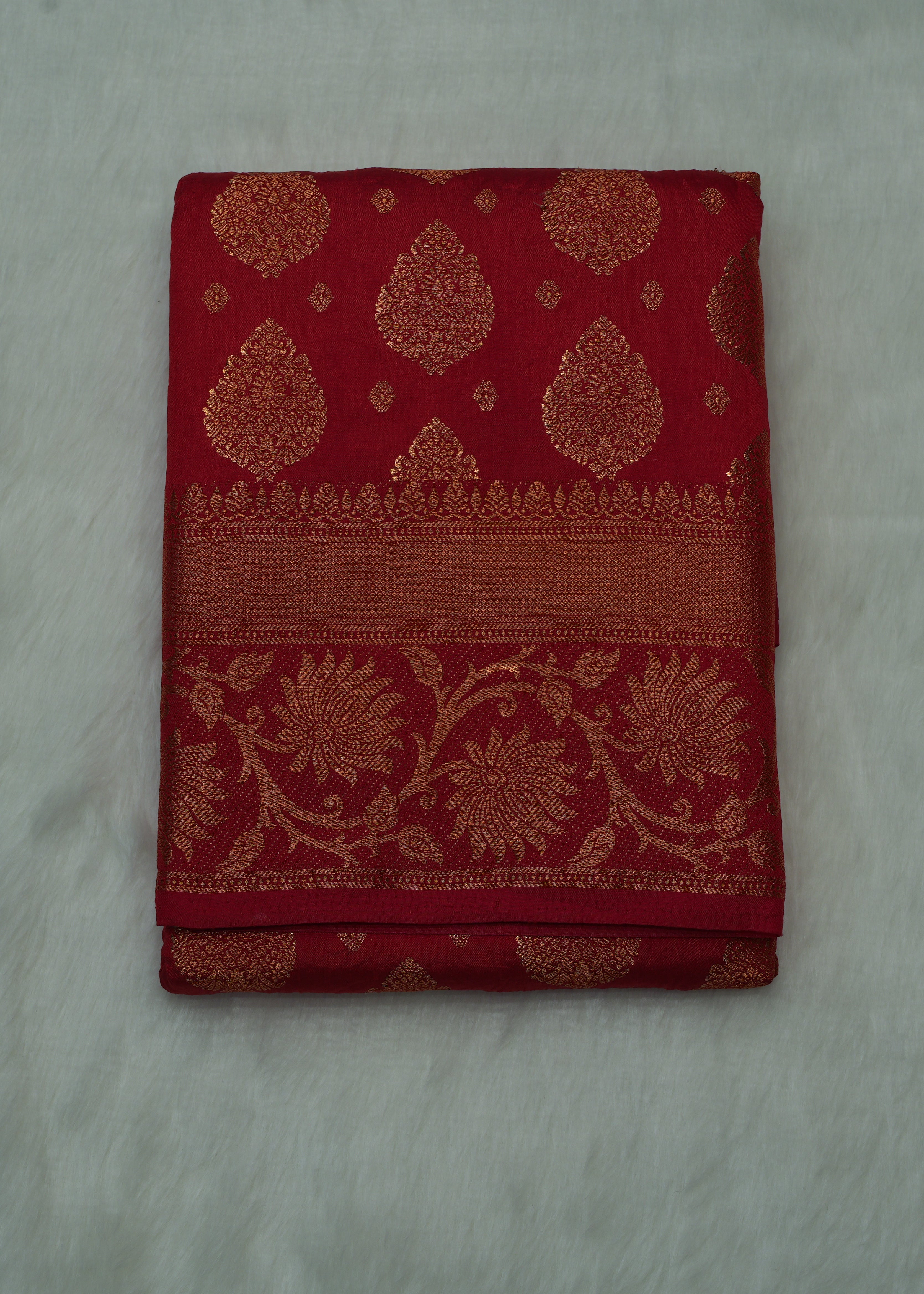 Red fabric with gold patterns on a light gray background