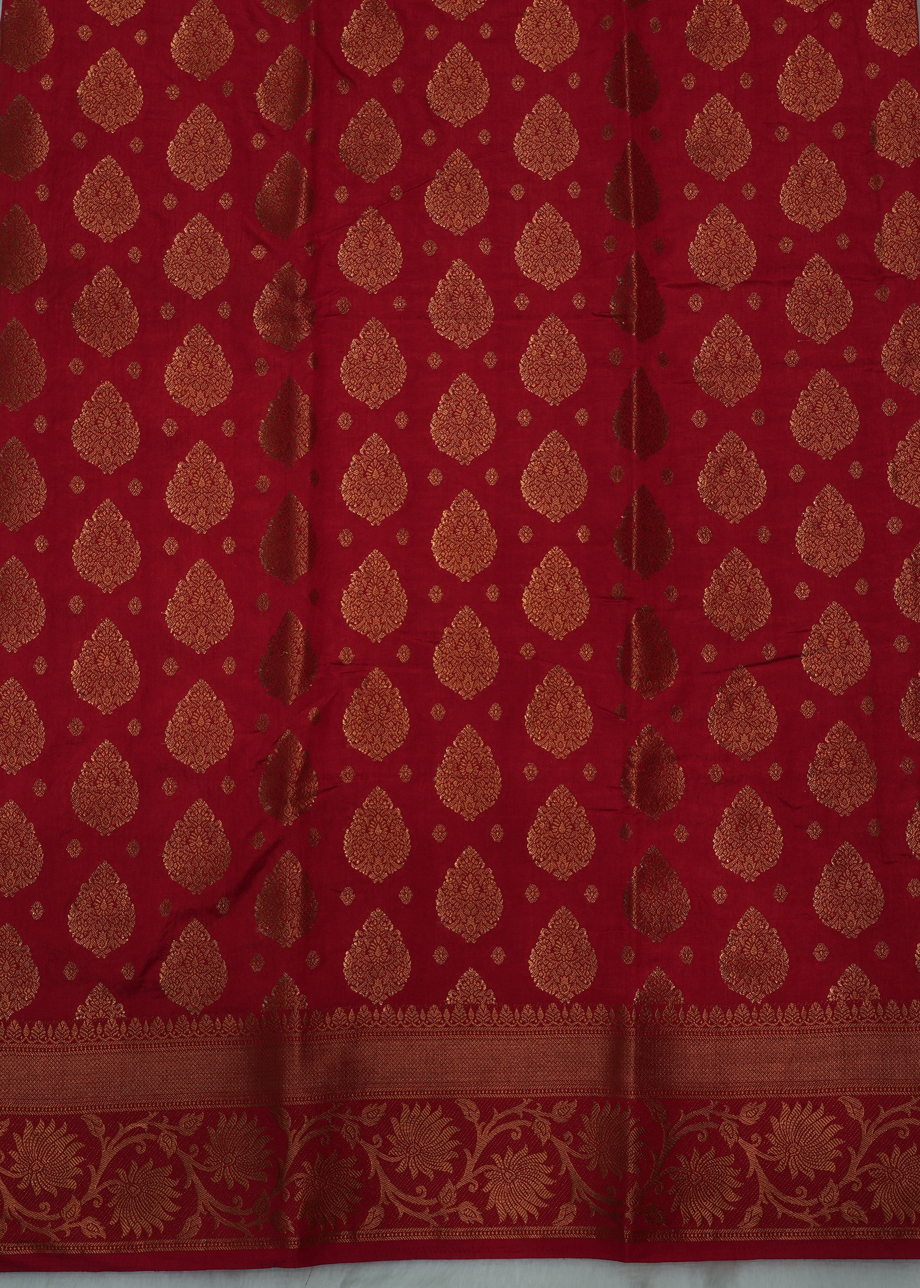 Red fabric with gold patterns on a gray background