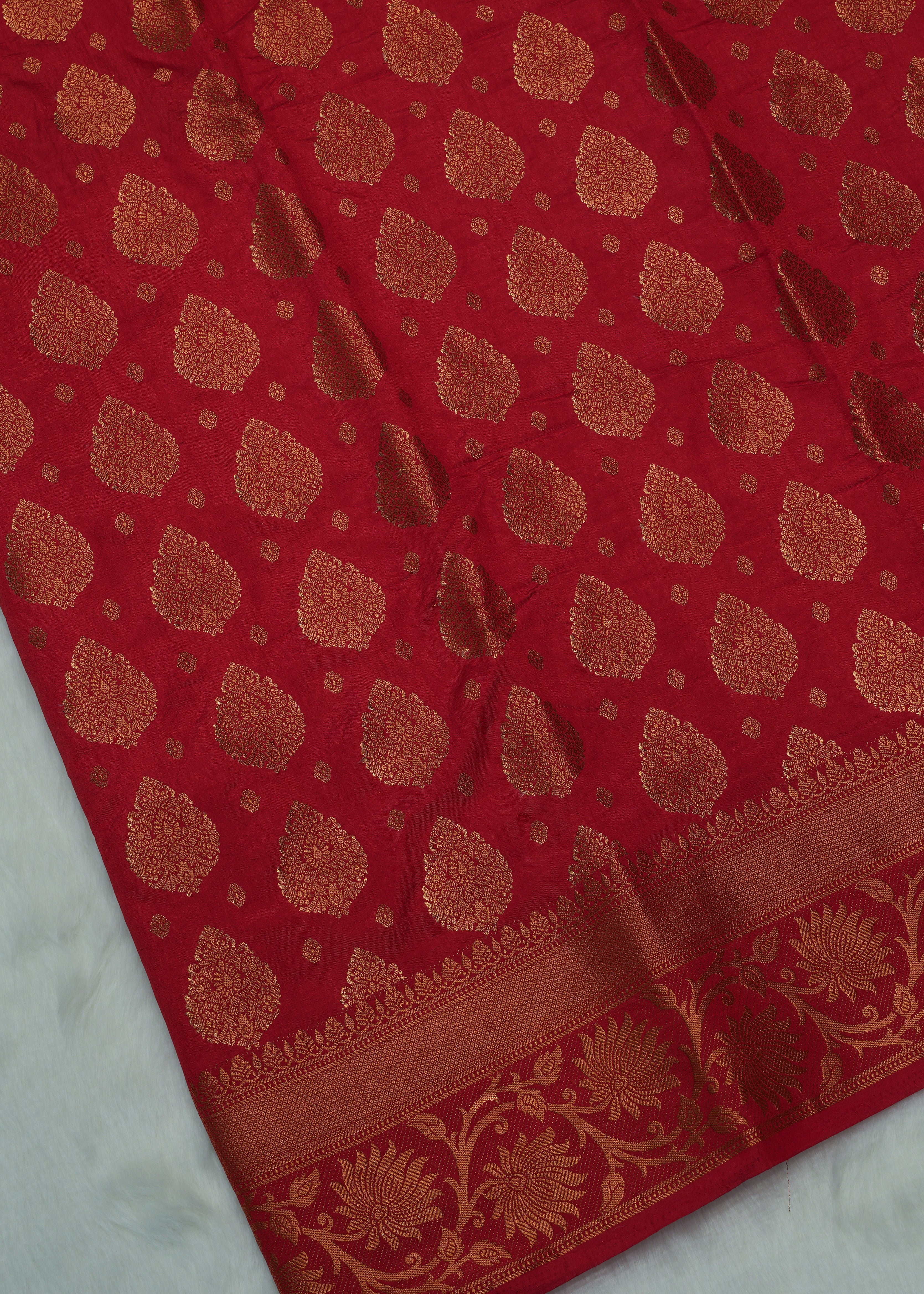 Red fabric with gold pattern on a white background