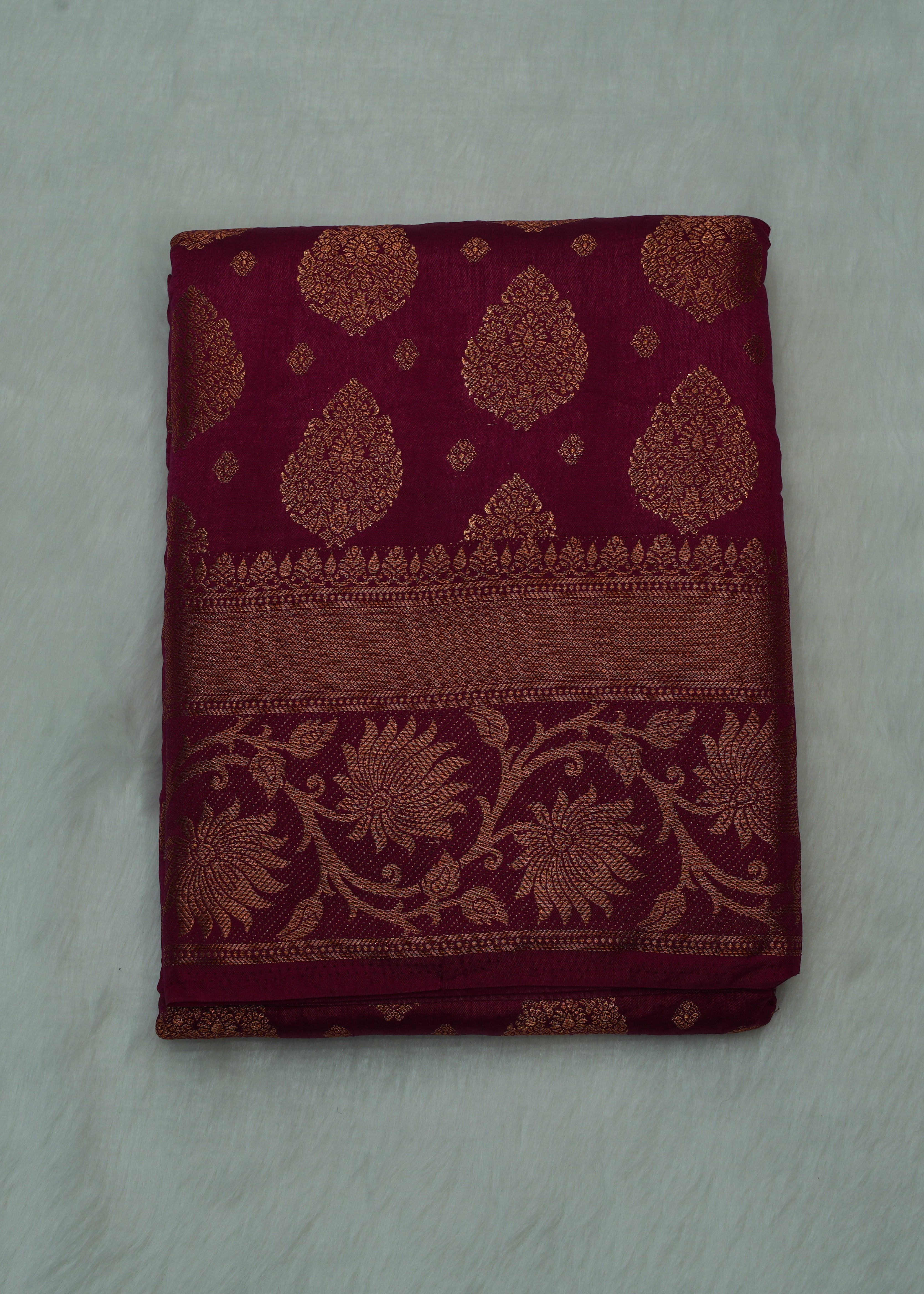 Folded fabric with intricate patterns on a light gray background