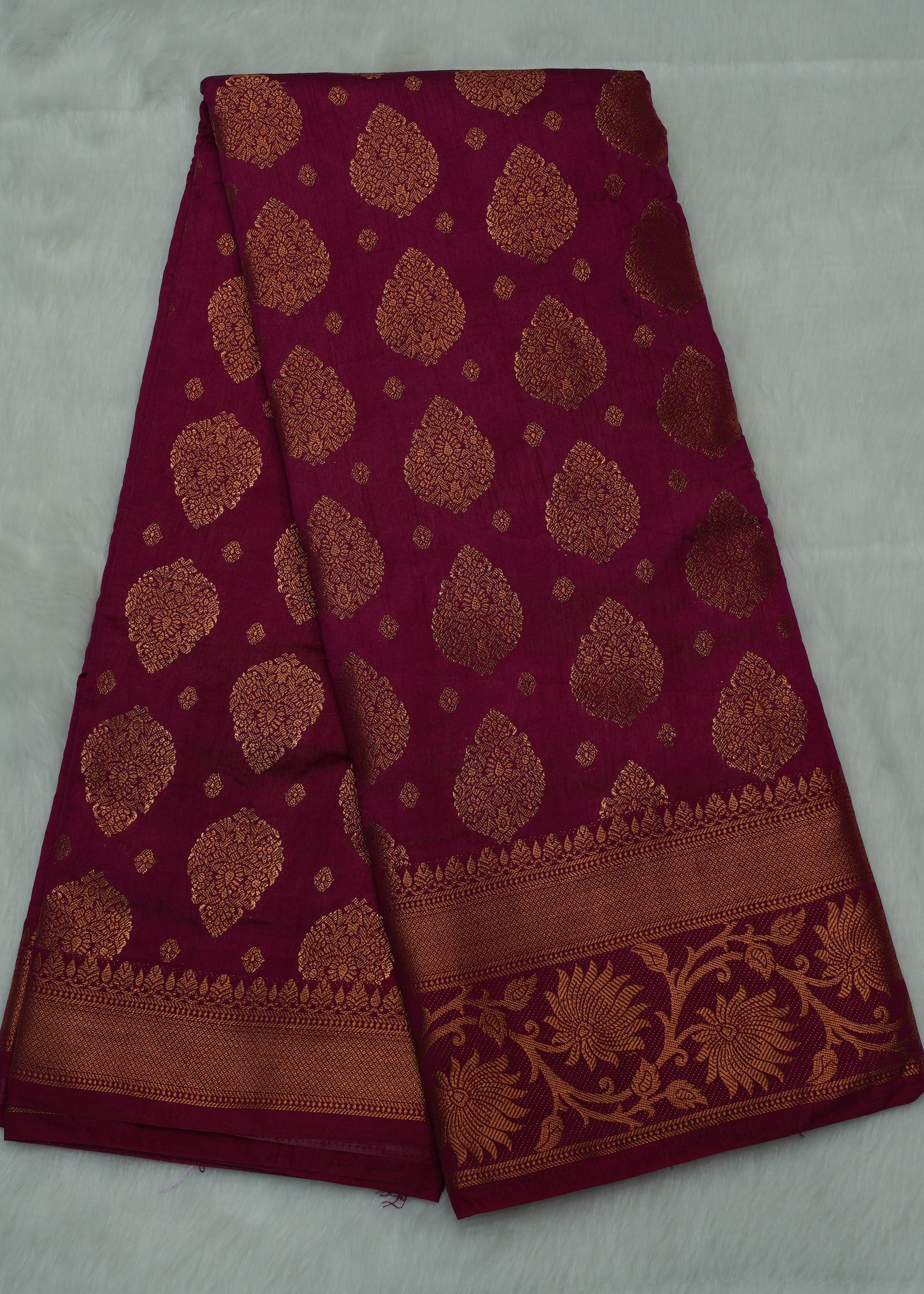 Maroon fabric with gold patterns on a white background