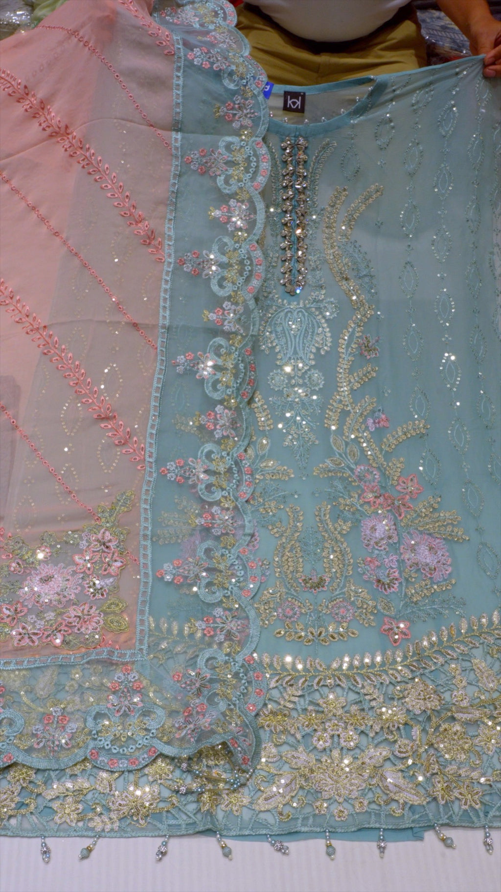 Close-up of a piece of fabric with intricate embroidery and embellishments.