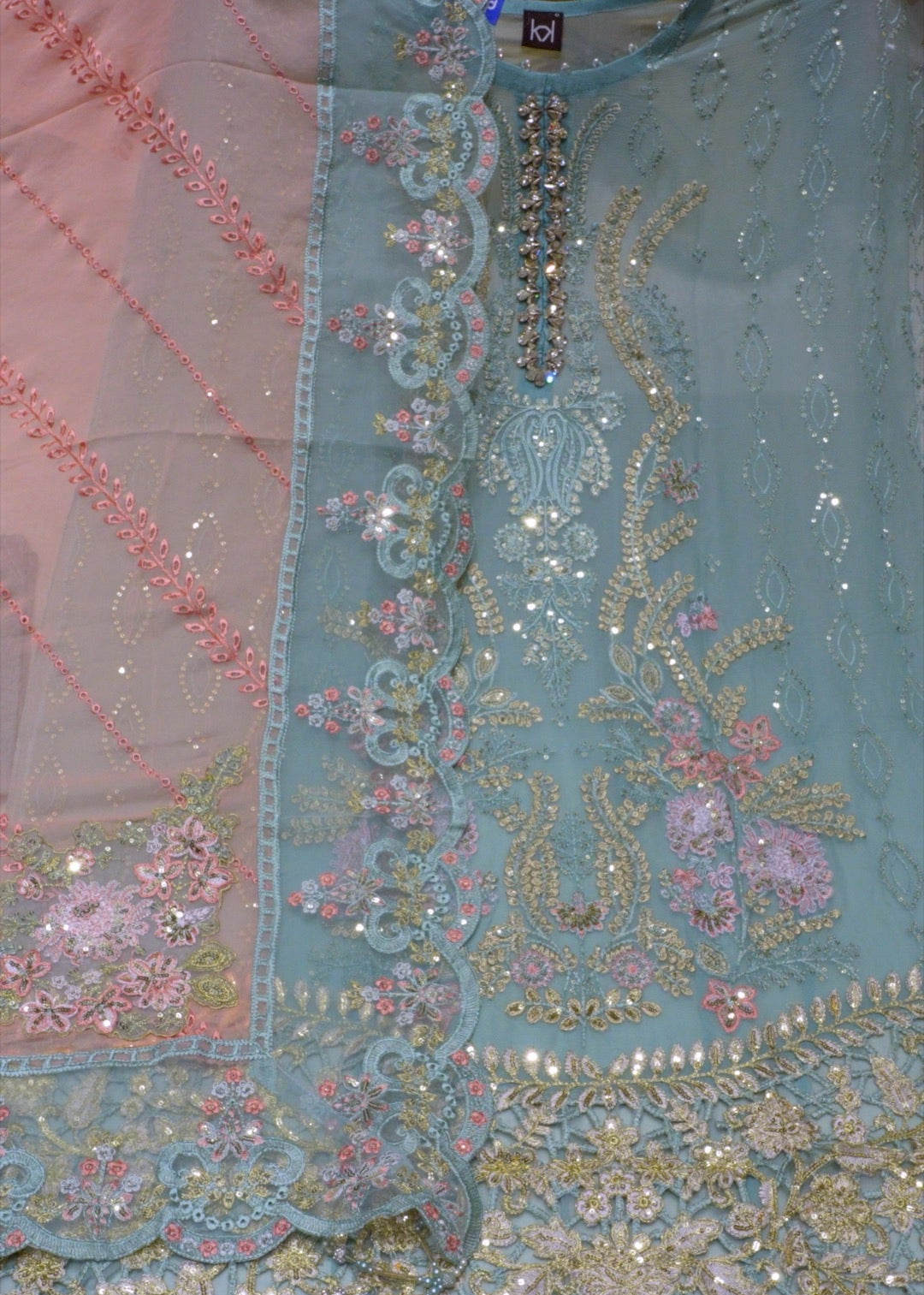 Close-up of a piece of fabric with intricate embroidery and embellishments.